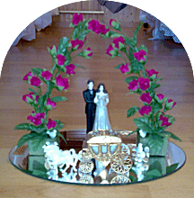 Brautpaar mit Kutsche und Rosenbogen auf Spiegel als Link zu Hochzeitsdekorationen im Shop.