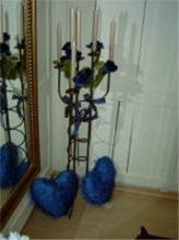 Kerzenständer und 2 blaue Herz Kissen mit Link auf Dekomaterial zum Mieten im Shop.